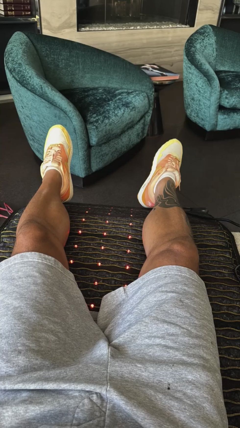 a POV picture of Ricky Martin's legs, in grey sweat shorts and sneakers.