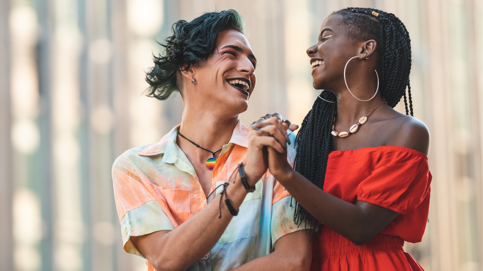 A stock photo of a couple holding hands and smiling at one another.