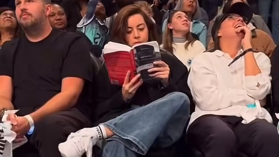 Actress Aubrey Plaza reading a book court side at a WNBA game