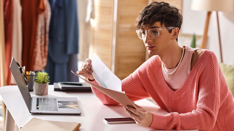 androgynous nonbinary transgender person reviewing paperwork home office