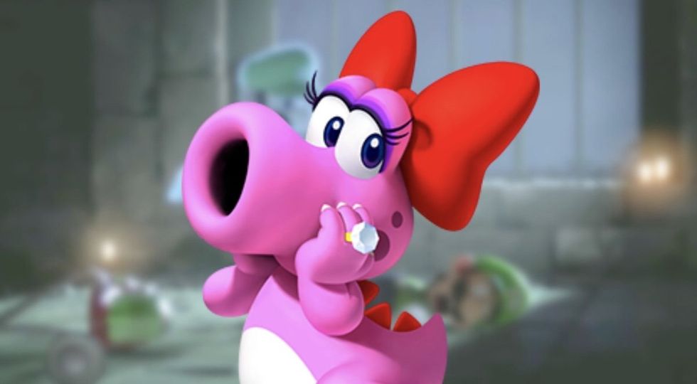 Birdo is a character from the Mario series. He is a pink dinosaur-like creature with a large suction-cup nose. He has long black eyelashes, an oversized red ribbon on the back of his head, red scales on his spine and tail, and white spots on his belly. He wears a large diamond ring on his middle finger.