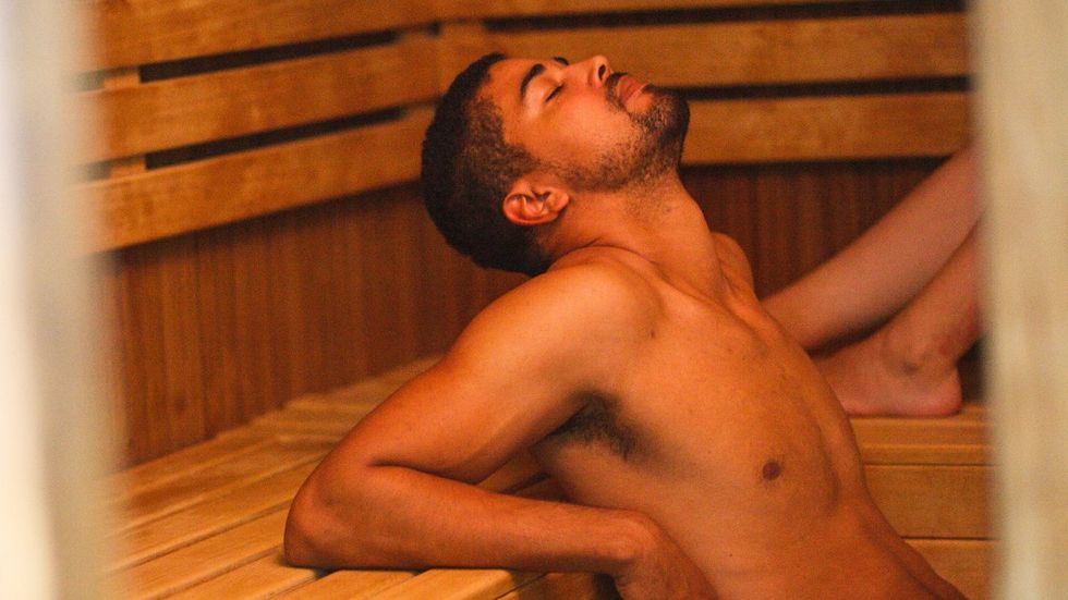 gay bathhouse: gay man relaxes in the sauna