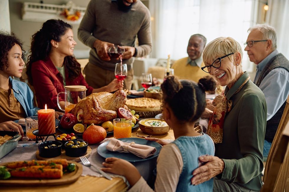 Happy multiracial extended family having a meal on Thanksgiving at dining table