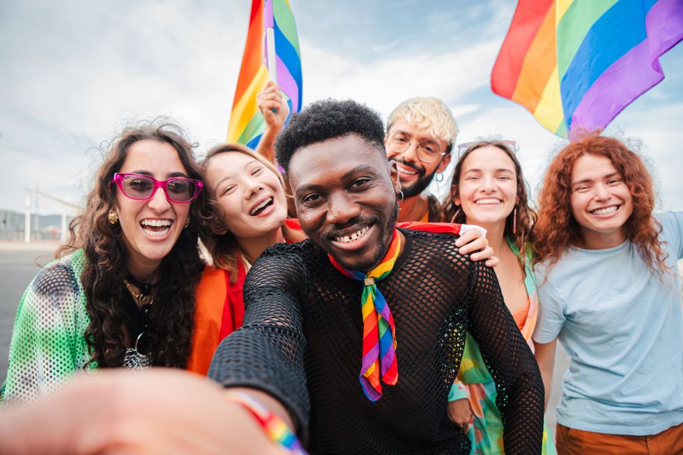 Happy multiracial young adult people having fun celebrating gay pride event. Group of diverse friends with different age and race having fun during LGBT social party. Sexual rights defense festival