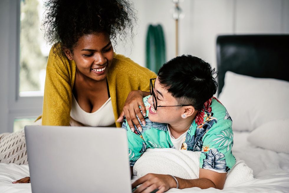 lesbians with a laptop on bed