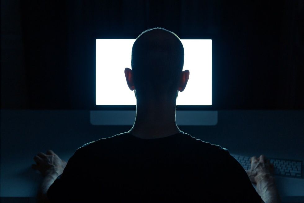 man in the dark looking at a computer screen