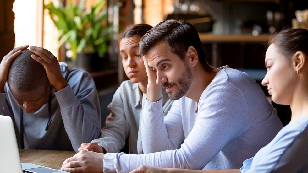 sad queer friend group looking at a laptop