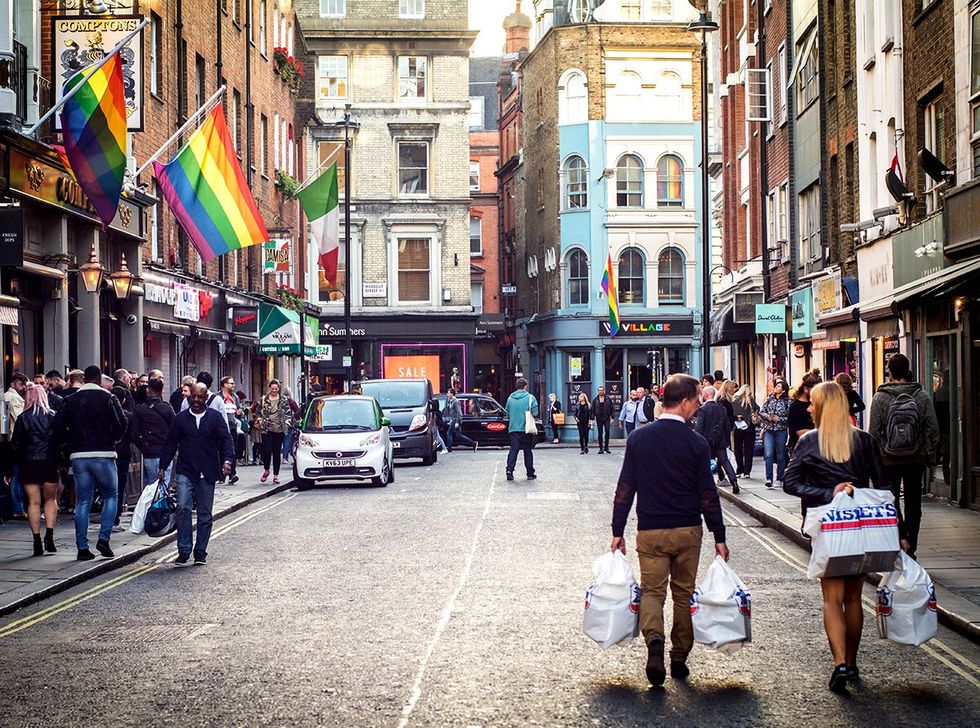 Shoppers walking down a Soho street in London westend gayborhood UK