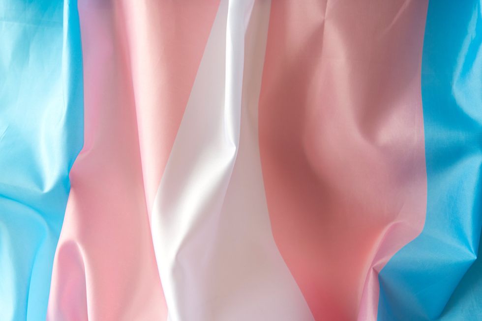 Transgender fabric flag with white, pink, blue strips. Close-up transgender pride flag as background or texture