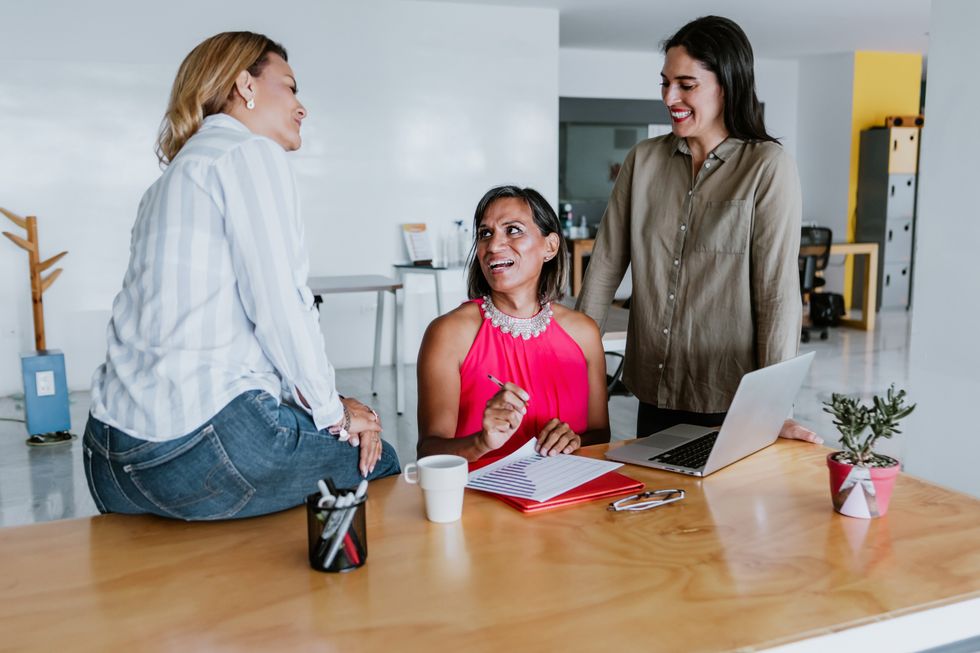 transgender latin woman working with women coworkers at the office in Mexico Latin America