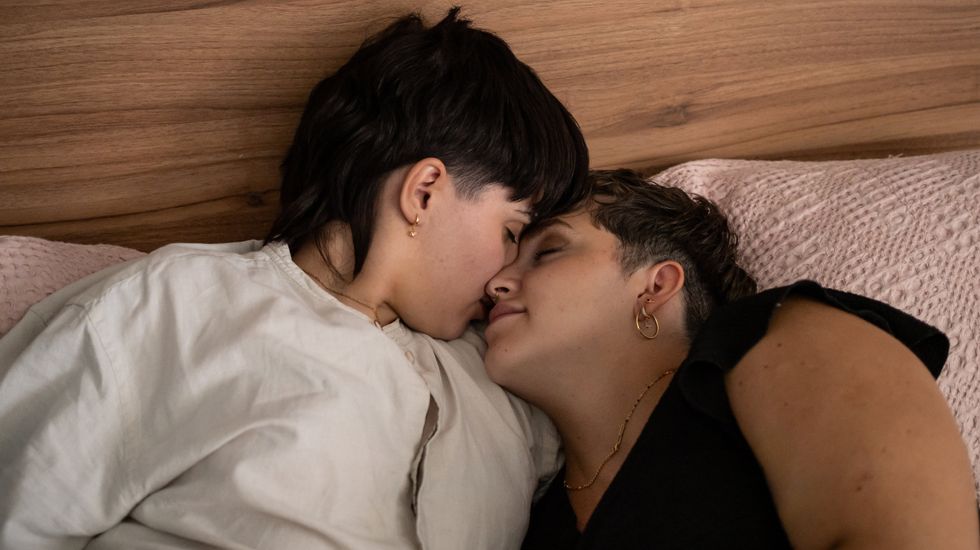 Two lesbians snuggling in bed