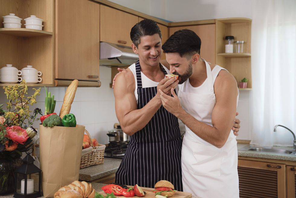 two men cooking and eating