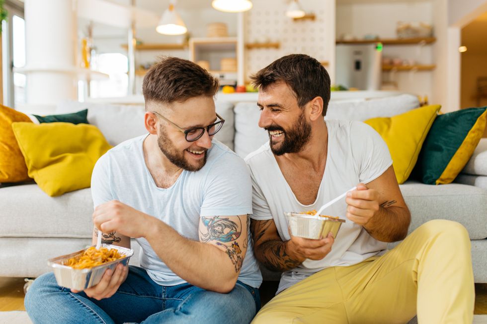 two men eating and laughing together