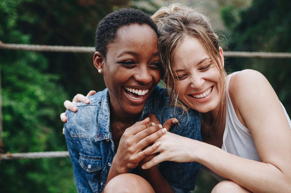 Two women holding each other and laughing