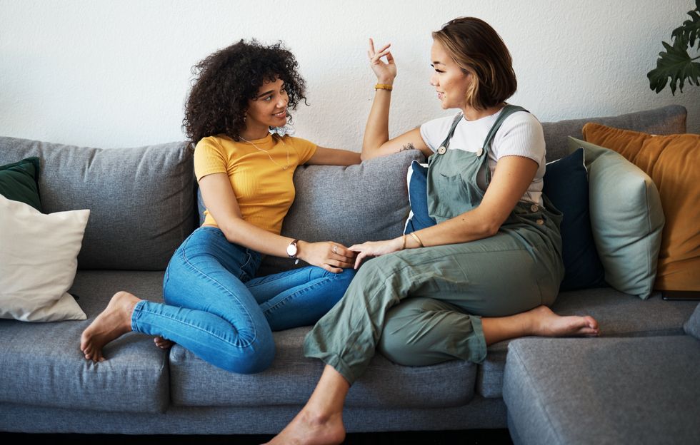 Two women sitting on a couch talking