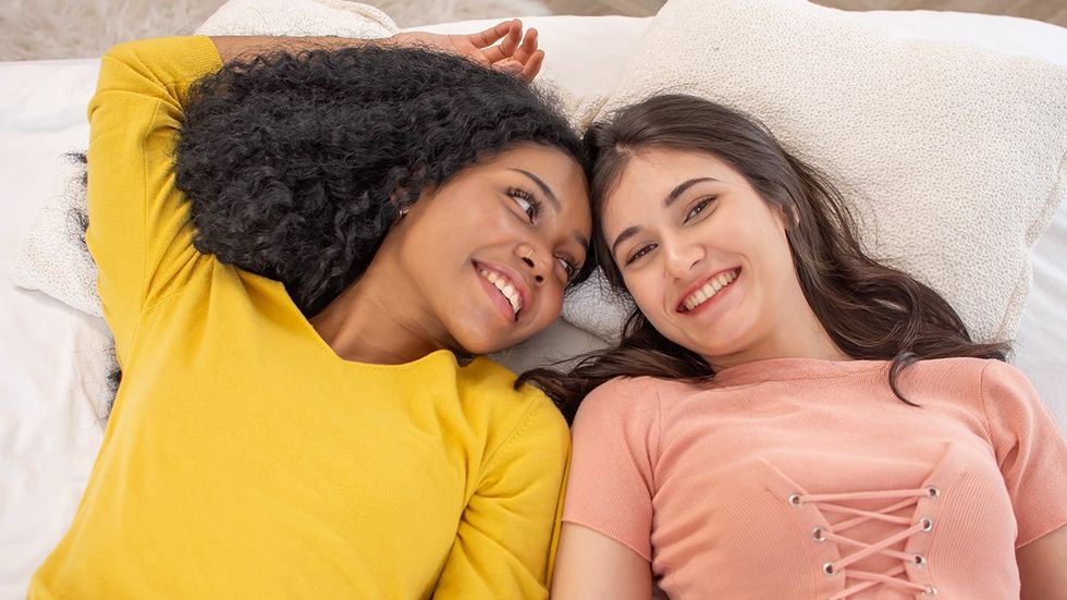 two young women lay in bed