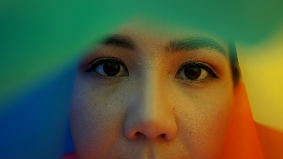 young asian woman in a rainbow flag