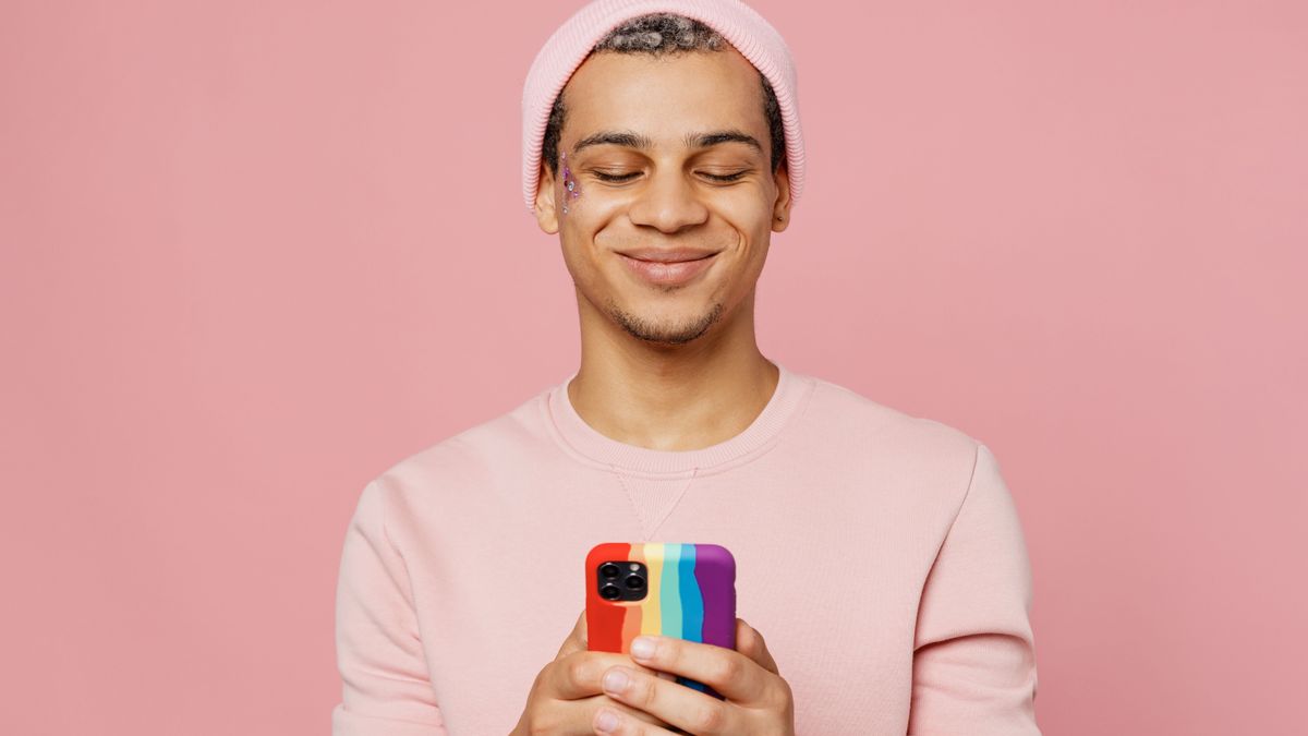 Young person holding a rainbow cell phone