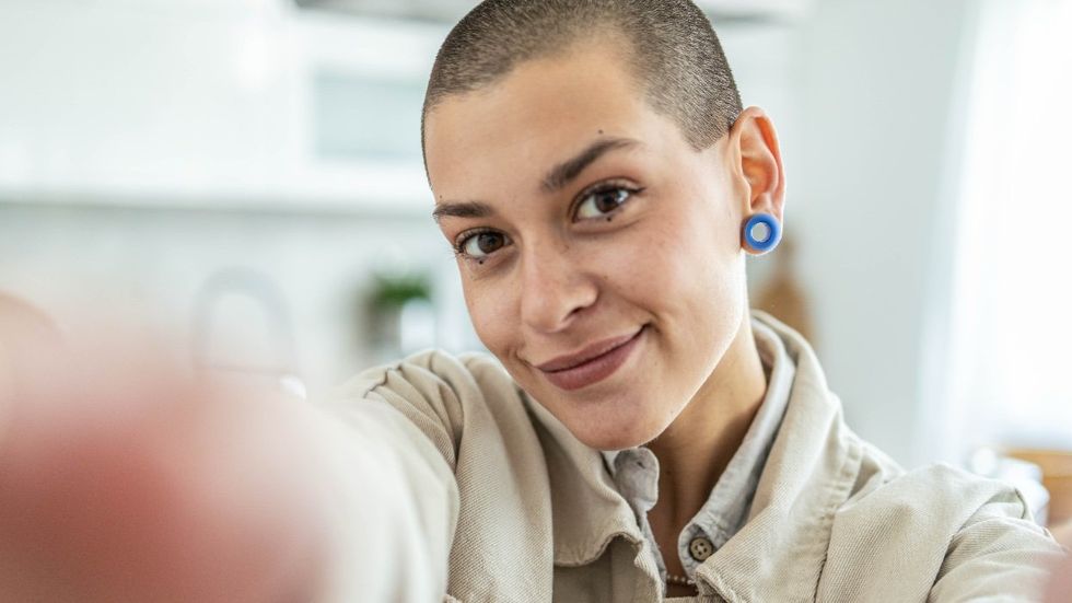 Young short hair girl smiling happy make selfie using mobile phone in her hands.