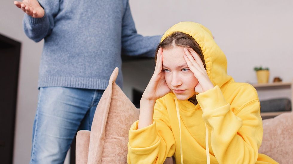 young woman getting yelled at by parent